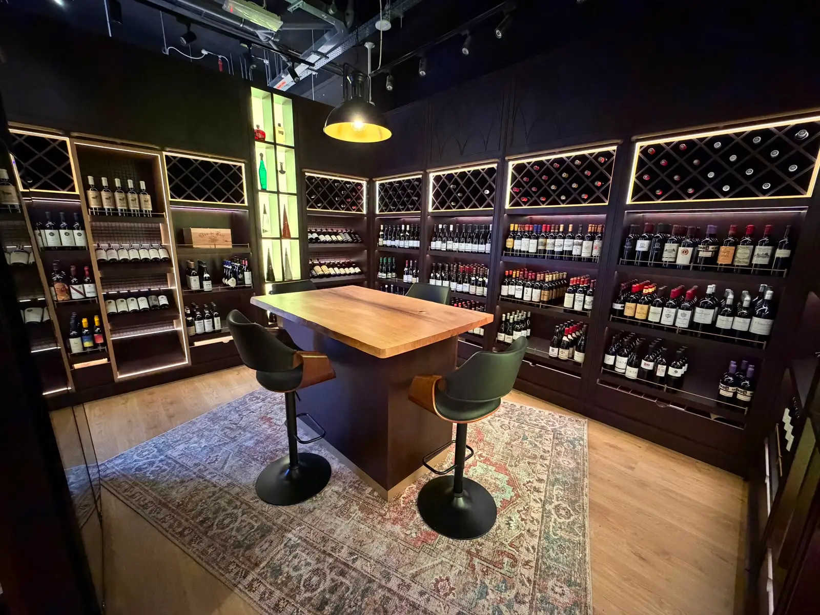Fine wine shelving in walnut, bottles displayed under warm backlighting.